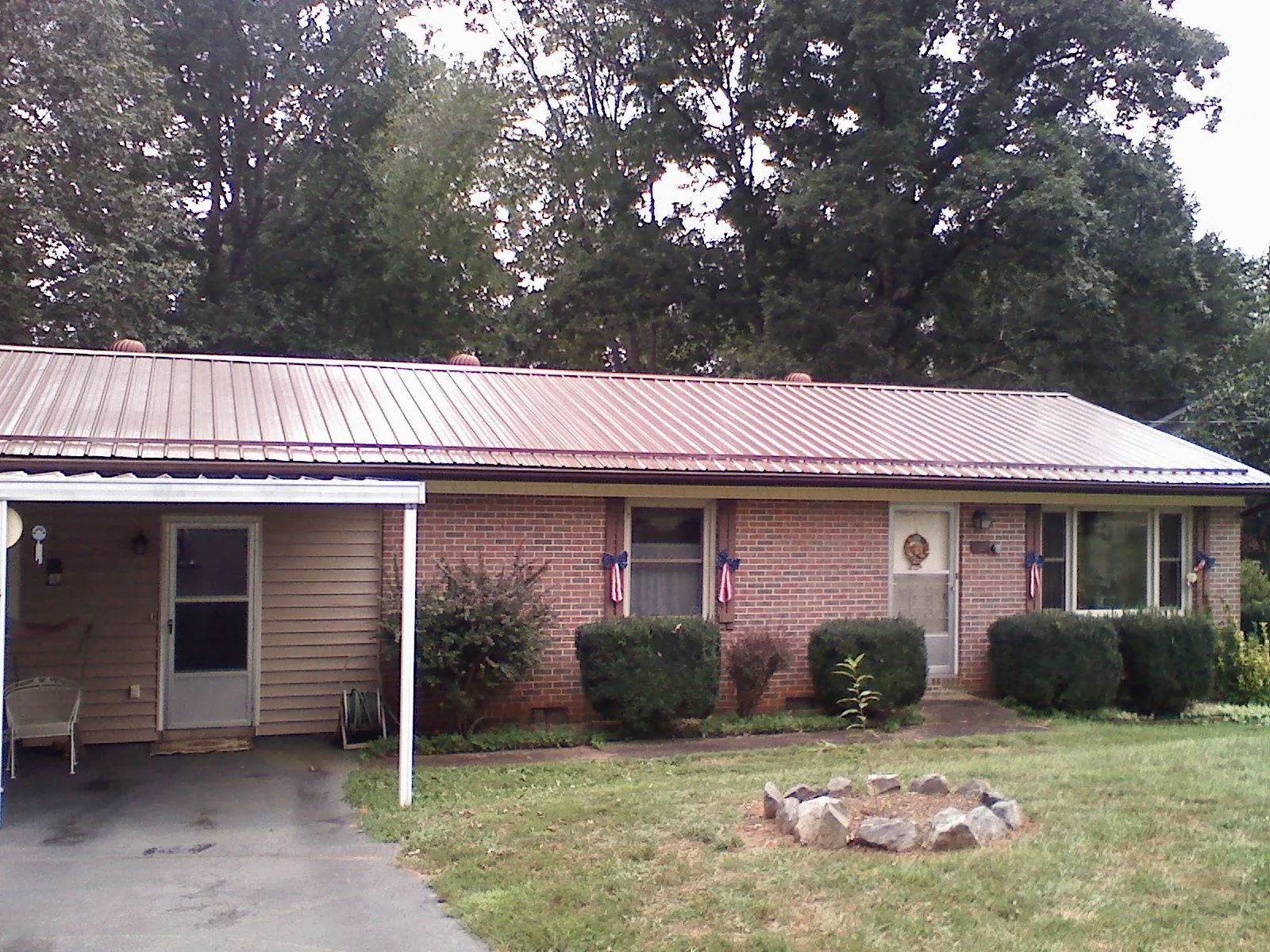 Bronze metal roof and carport on a brick ranch home — Roof Repair work by our crew in Mullins