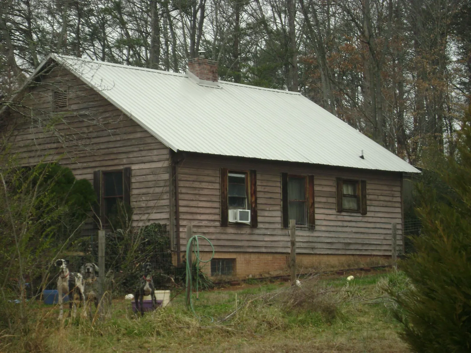 White metal roof on an old wood sided farmhouse, from a Metal Roof Installation job in Mullins